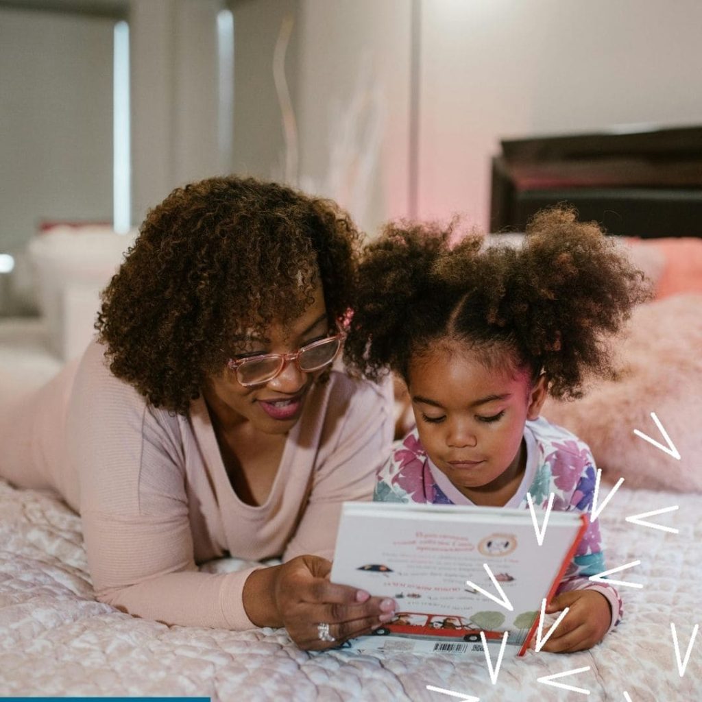A black woman reads a book with her daughter