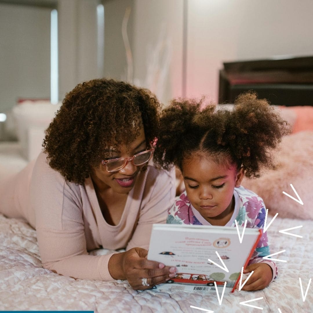 A black woman reads a book with her daughter