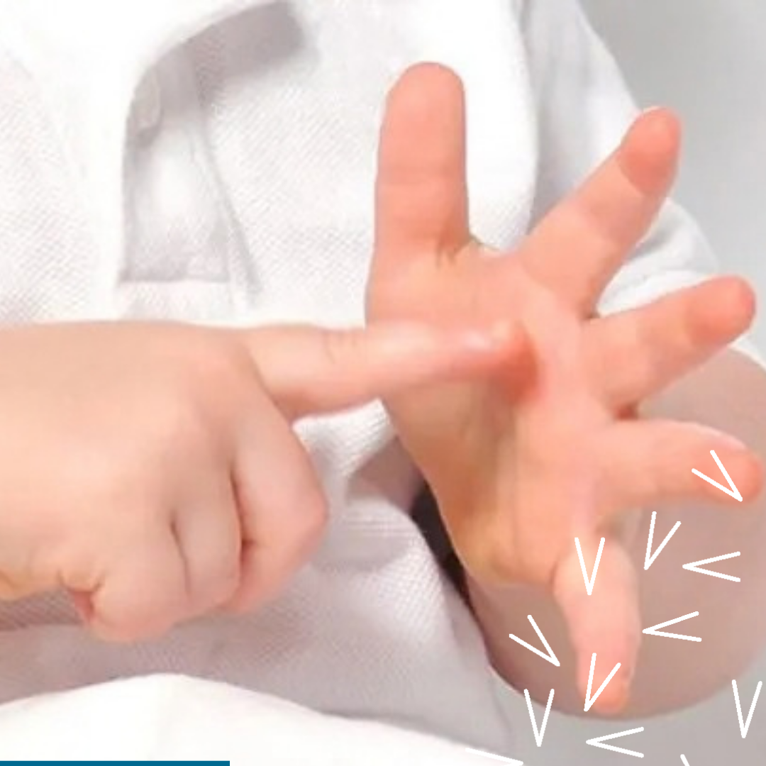 The hands of a white toddler signing